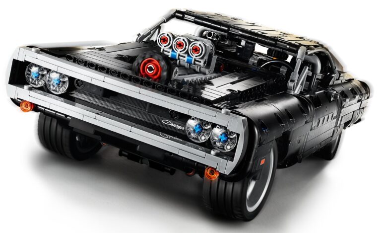 Il LEGO Technic 42111 Dom's Dodge Charger visto di tre quarti anteriore su sfondo bianco: una muscle car nera con calandra e paraurti argentati, fari tondi e un grande compressore con prese d'aria rosse e argento che spunta dal cofano